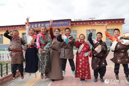 甘肃省甘南藏族自治州玛曲县寄宿制藏族小学，藏族教师德吉草和学生在一起。人民网记者 王金雪摄